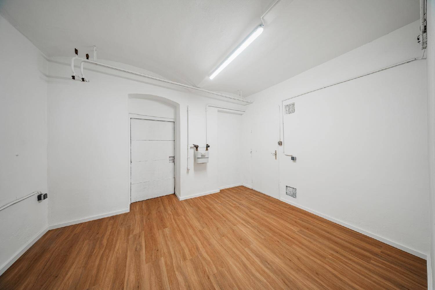 Heller Kellerraum mit Laminatboden und weißen Wänden, bietet zusätzlichen Stauraum.