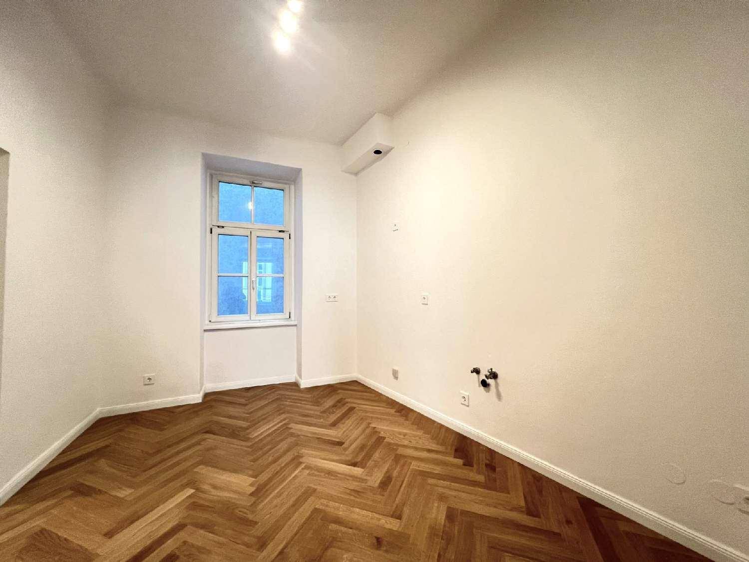 Geräumiges Zimmer mit Fischgrätparkett und einem Fenster, ausgestattet mit Heizkörper und Klimaanlage.