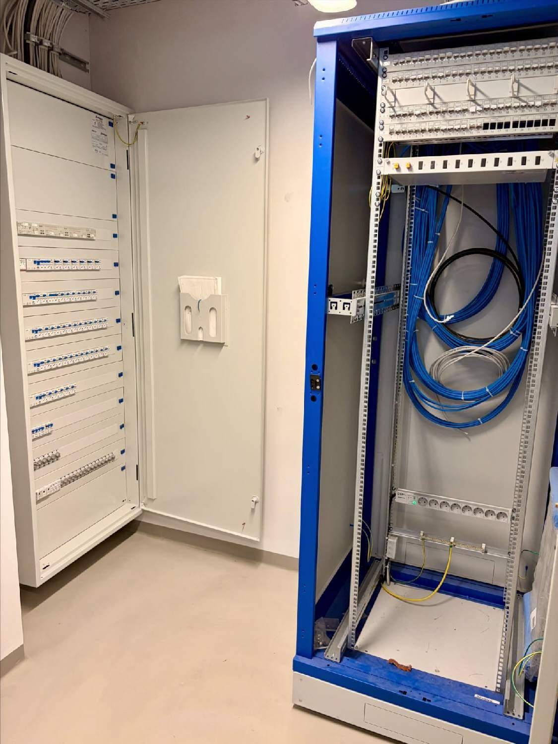 Technikraum mit Serverschränken und ordentlich verlegten Kabeln.