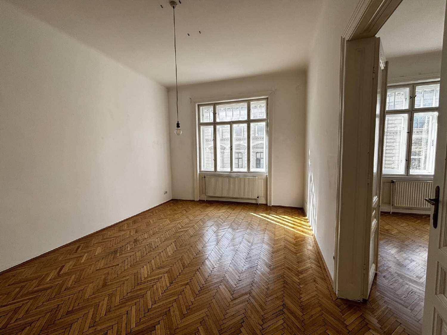 Großzügiges Zimmer mit traditionellem Fischgrätparkett und einem Fenster, das viel Helligkeit spendet.