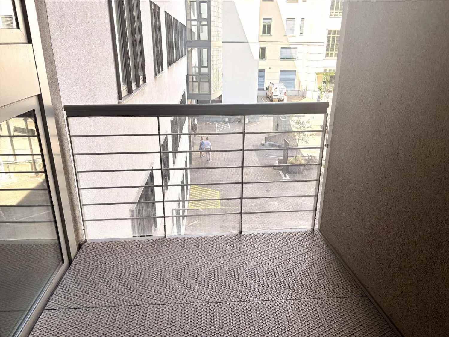 Kleiner Balkon mit Metallgeländer und Blick auf den Innenhof und umliegende Gebäude.