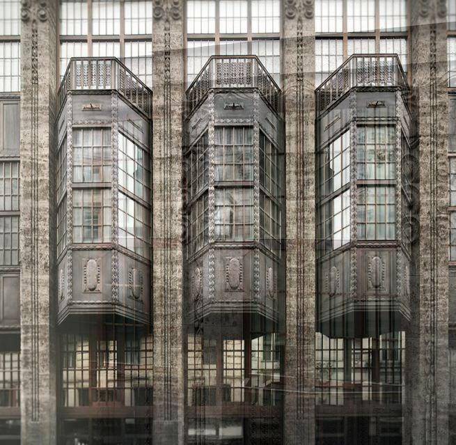 Detailansicht der historischen Fassade mit kunstvollen Erkern und großen Fenstern.