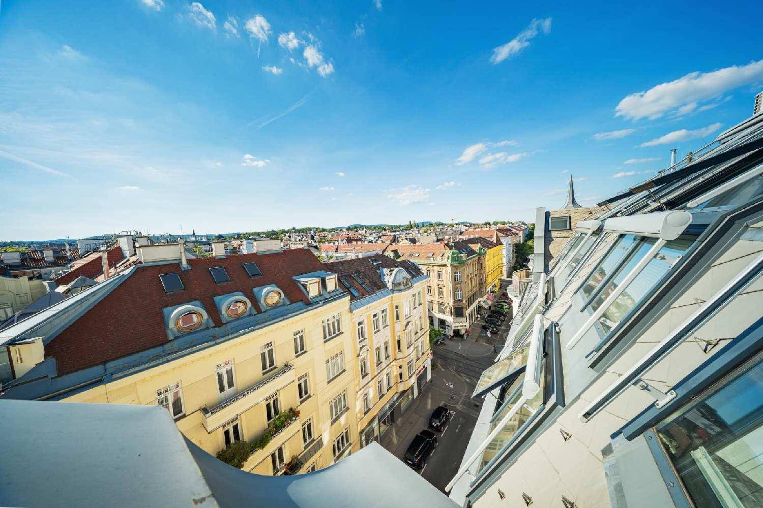 Weitläufiger Blick über die Dächer der Stadt mit historischen Gebäuden und sonnigem Himmel.