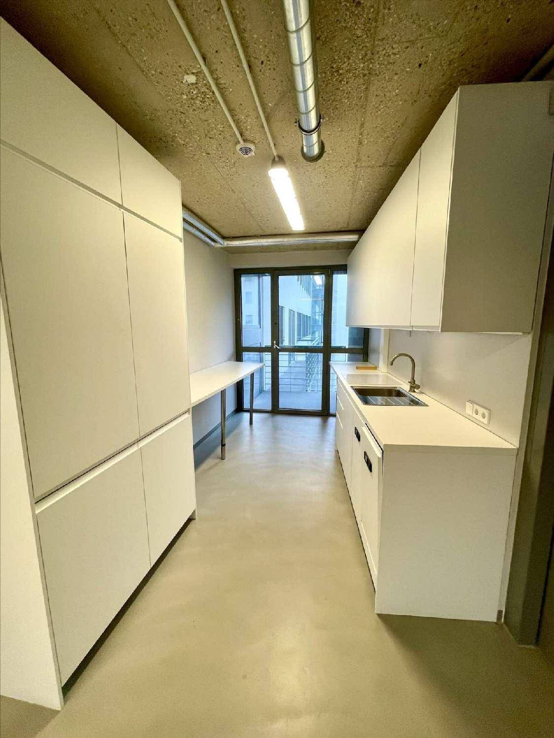 Moderne Küchenzeile mit weißen Schränken und Zugang zu einem Außenbereich.