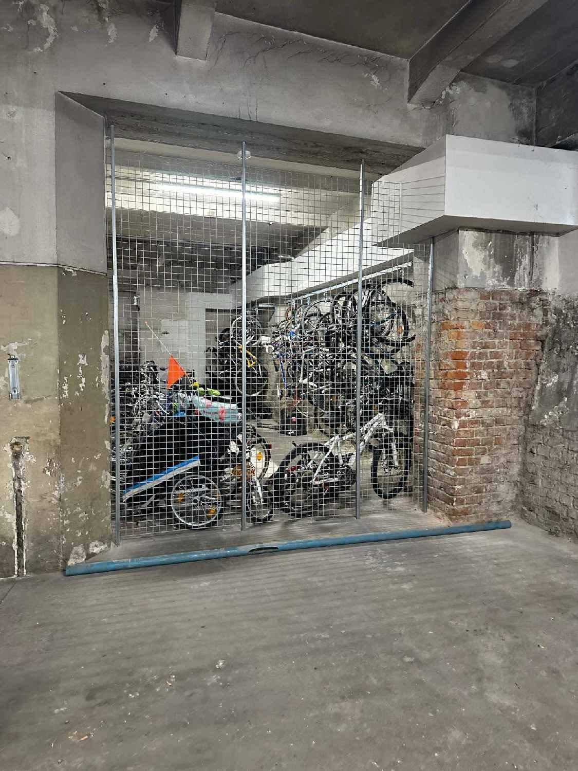 Abgeschlossener Fahrradabstellraum in der Tiefgarage mit vielen Fahrrädern in Metallregalen.