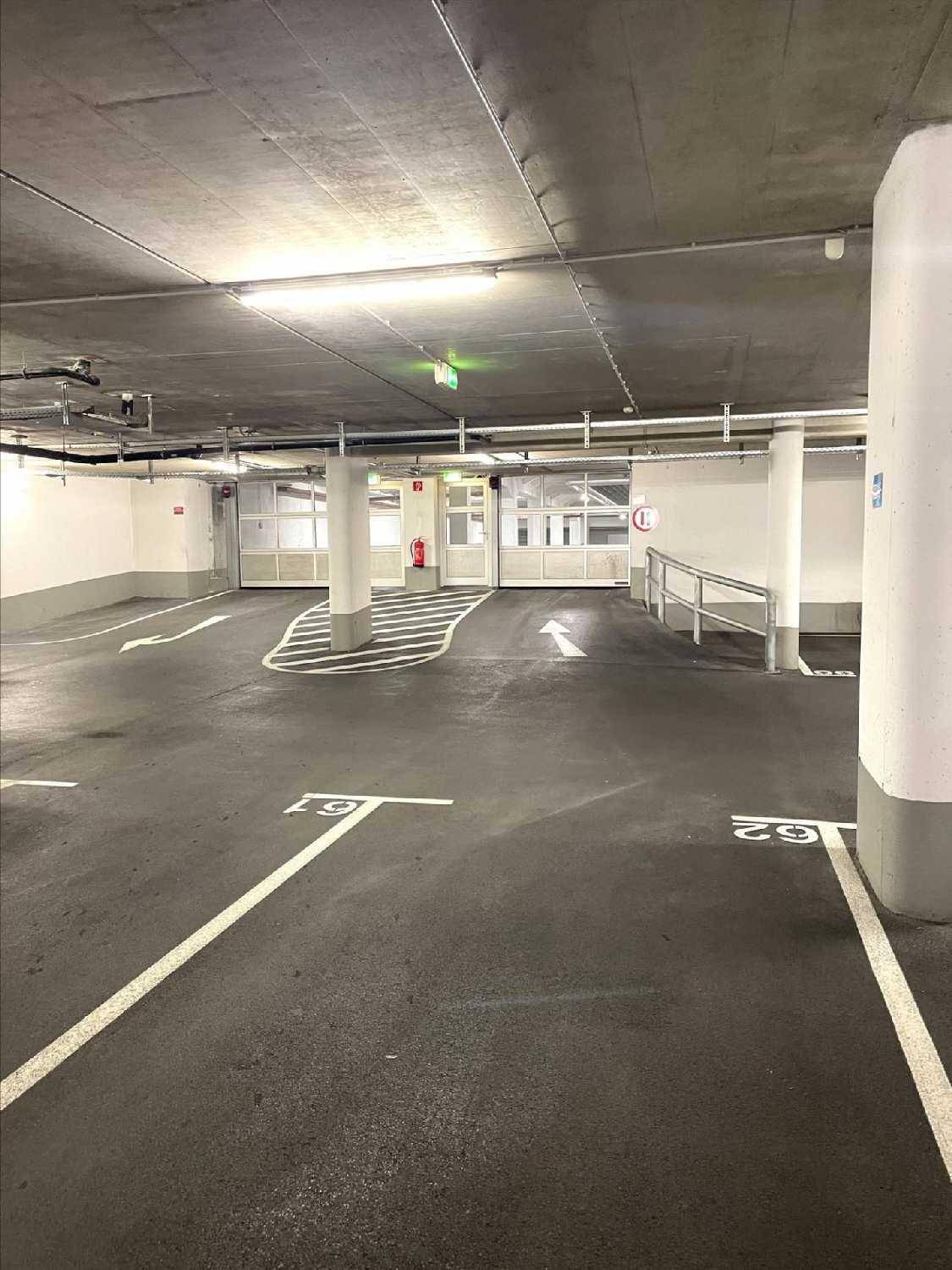 Geräumige Tiefgarage mit nummerierten Parkplätzen und klarer Fahrbahnmarkierung.