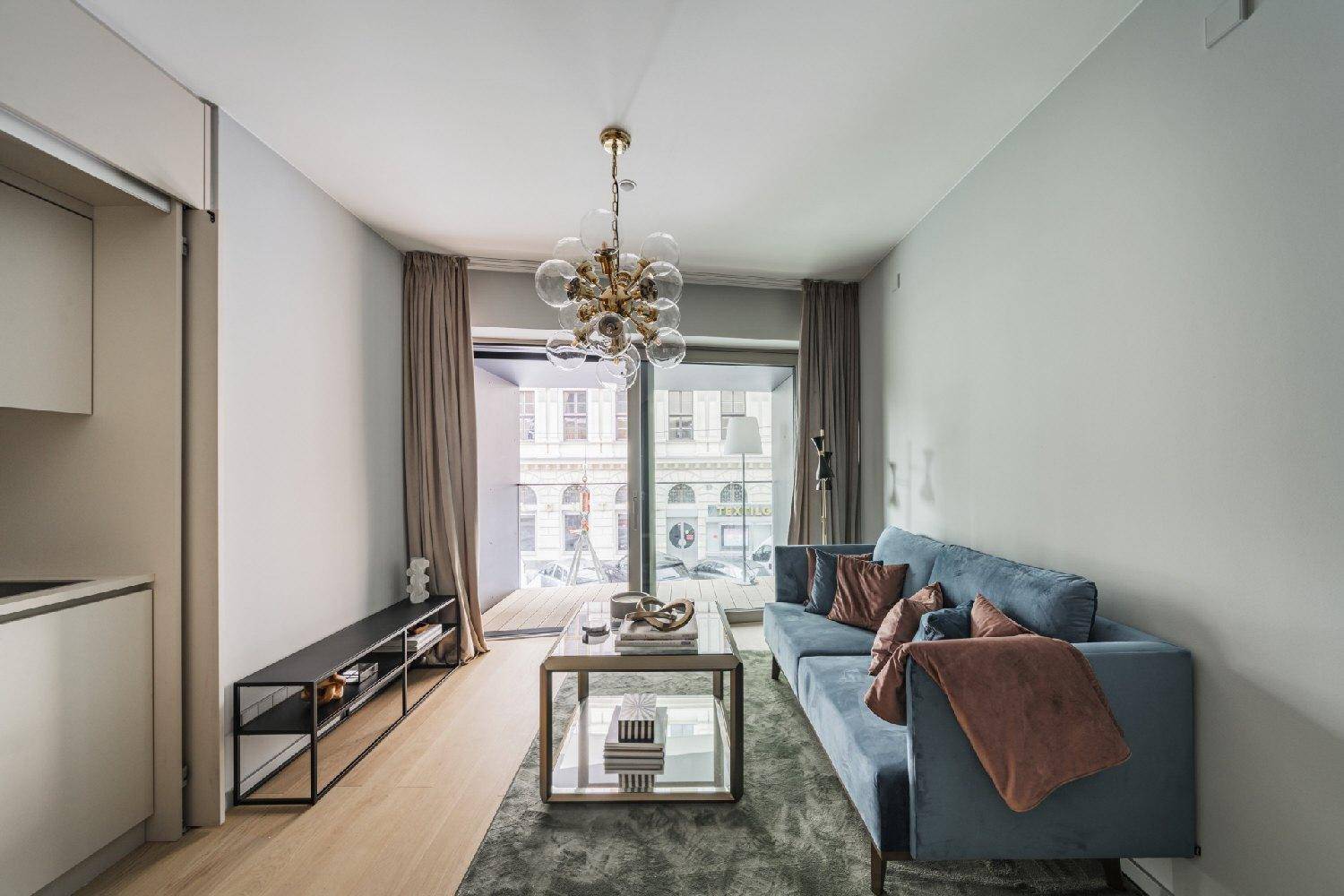 Gemütlicher Wohnbereich mit Zugang zum Balkon und Blick auf die Straße.