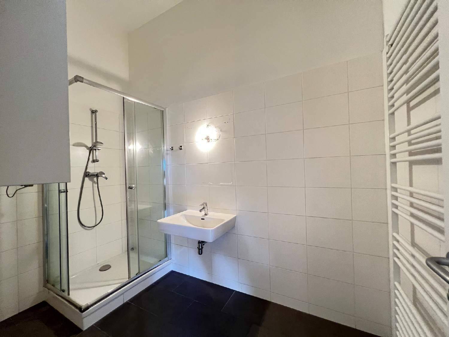 Funktionales Badezimmer mit Duschkabine, Waschbecken und weißen Fliesen.