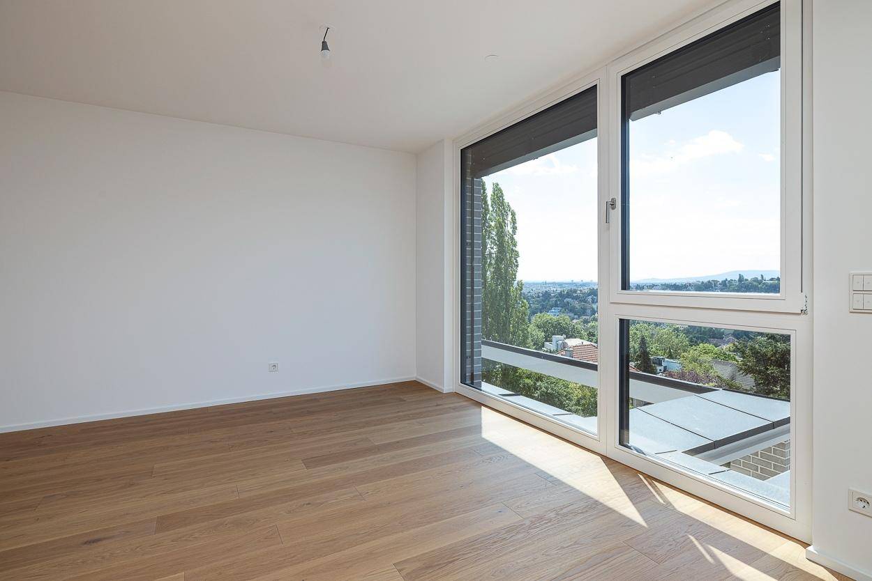 Heller Raum mit großen Fenstern und Holzboden, bietet einen schönen Ausblick auf die Umgebung.
