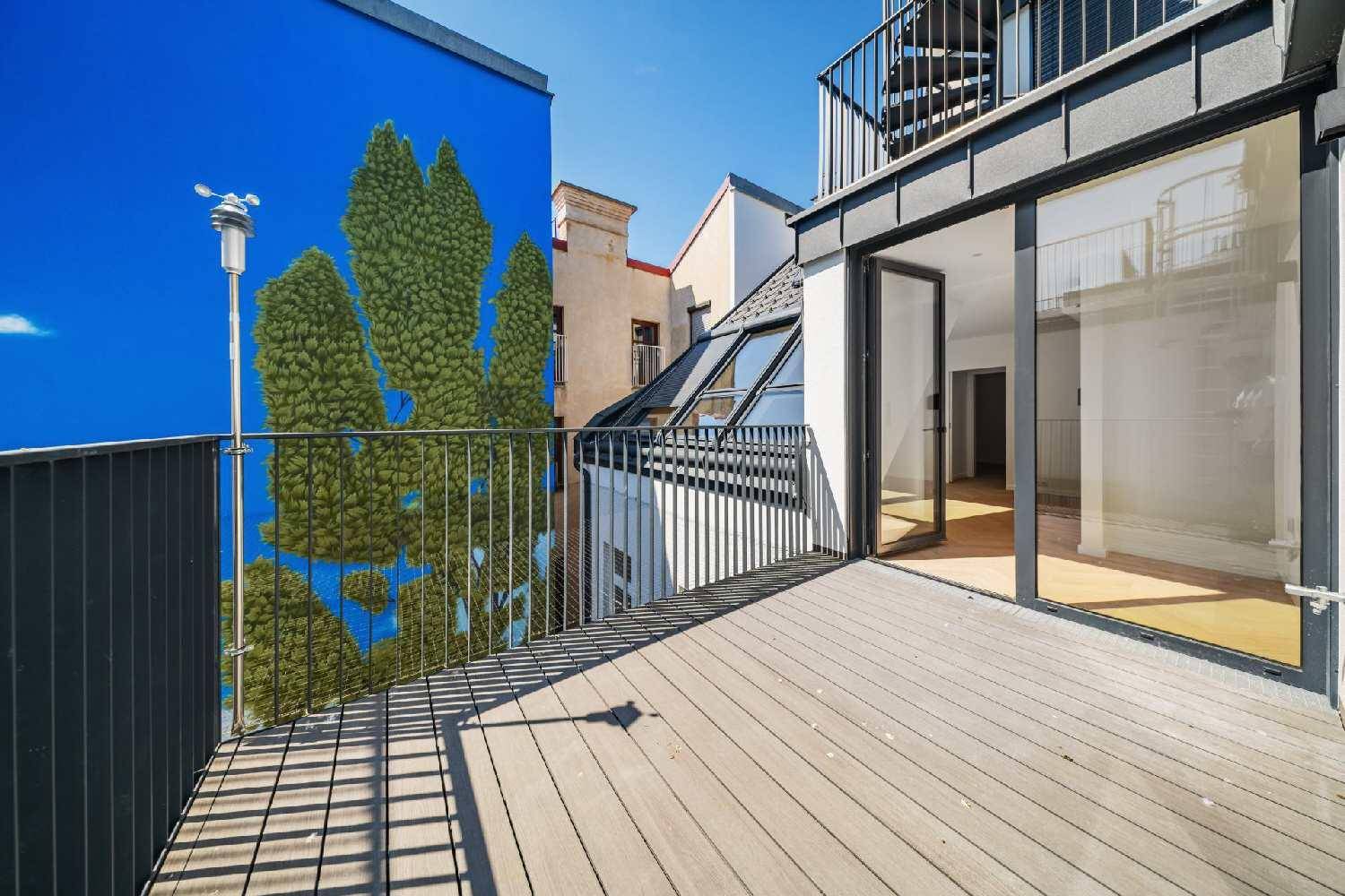 Geräumige Holzterrasse mit Metallgeländer und Blick auf eine farbenfrohe Wandmalerei.