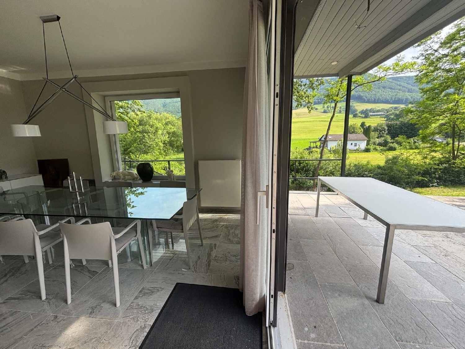 Eleganter Essbereich mit Glastisch, modernen Stühlen und direktem Zugang zur Terrasse.