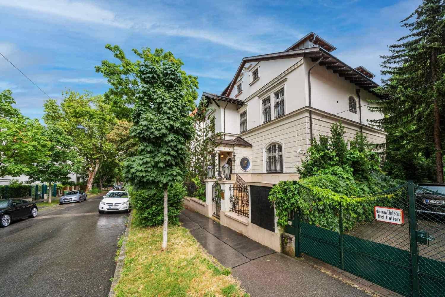 Elegante Stadtvilla mit gepflegter Fassade und Zufahrt in einer ruhigen Wohngegend.