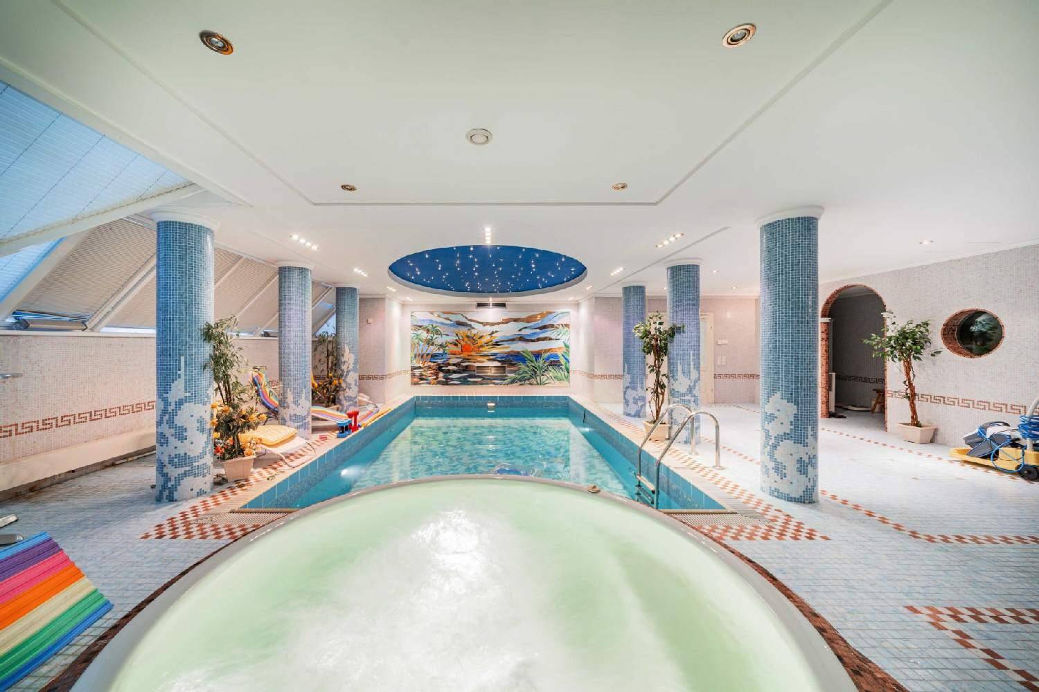 Großzügiger Innenpoolbereich mit Mosaikfliesen, Whirlpool und Sternenhimmel-Decke für Entspannung.