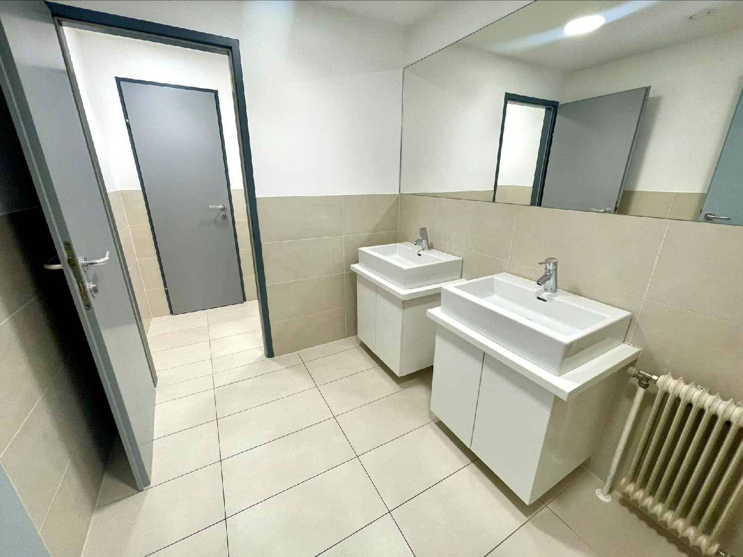 Modernes Badezimmer mit zwei Waschbecken, großem Spiegel und hellen Fliesen.
