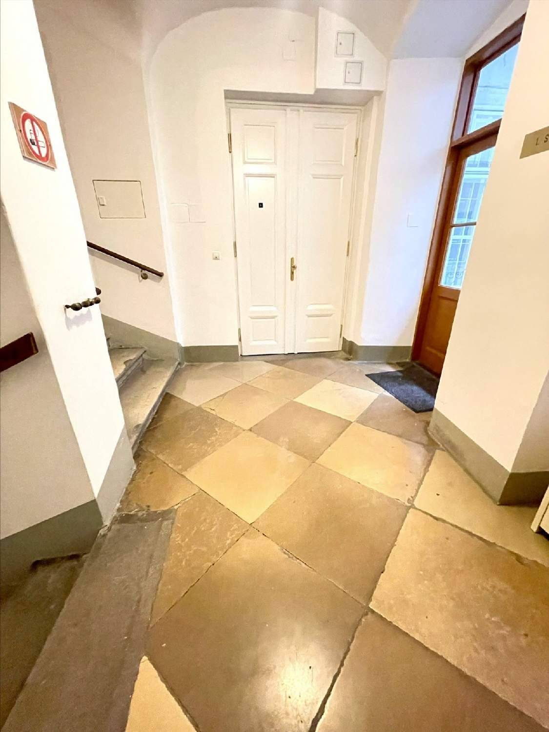 Eingangsbereich mit gemustertem Fliesenboden, Treppe und einer Doppeltür, die in die Wohnung führt.