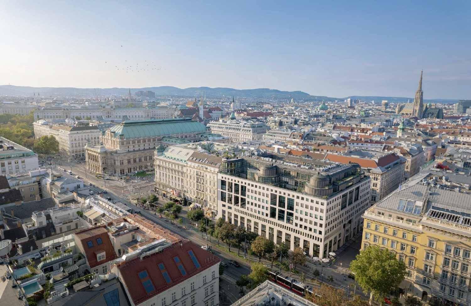 Panoramablick über eine historische Stadt mit vielen Gebäuden, Dächern und einem klaren Himmel.