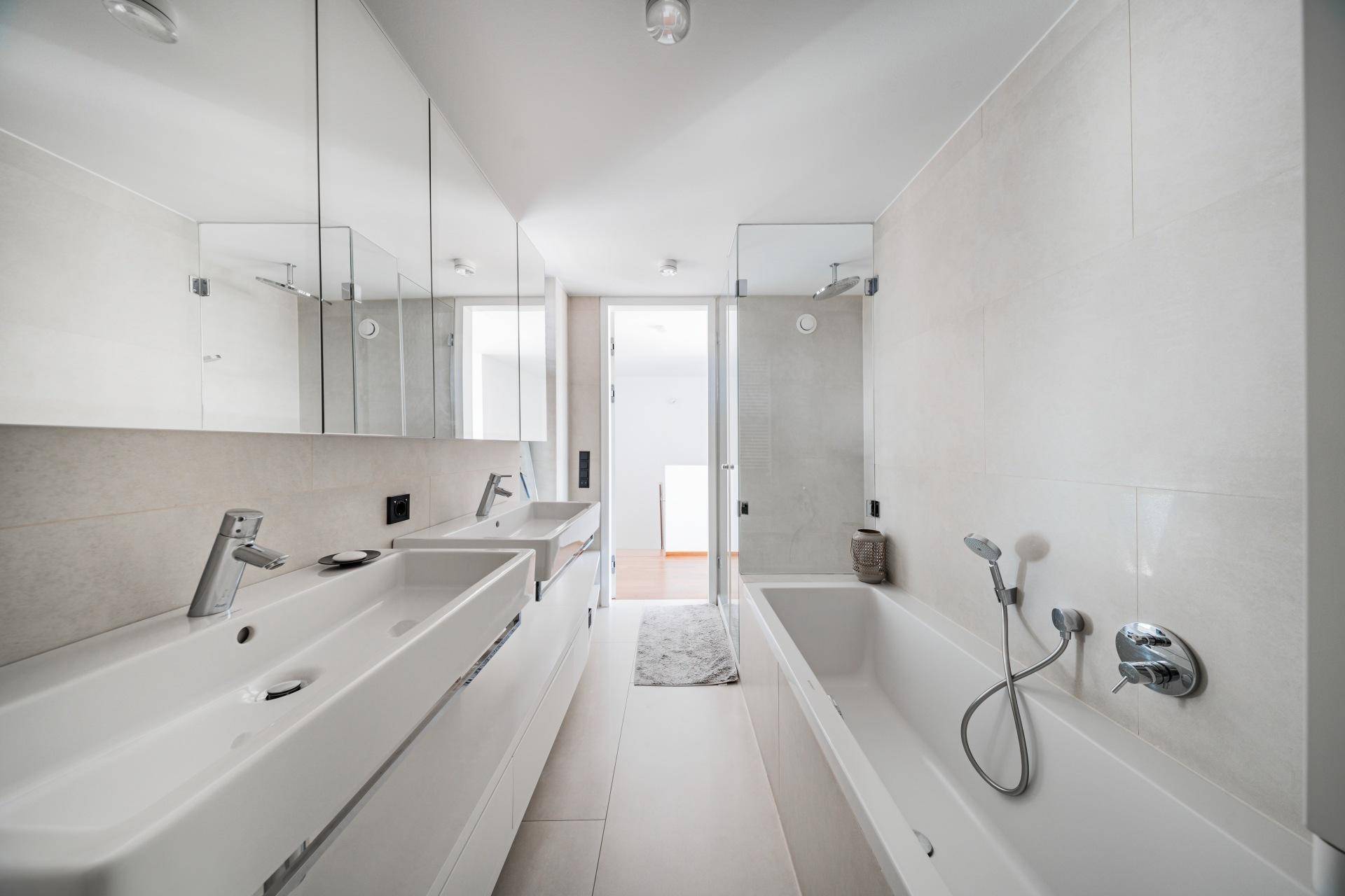 Modernes Badezimmer mit Doppelwaschbecken, Badewanne und separater Dusche.