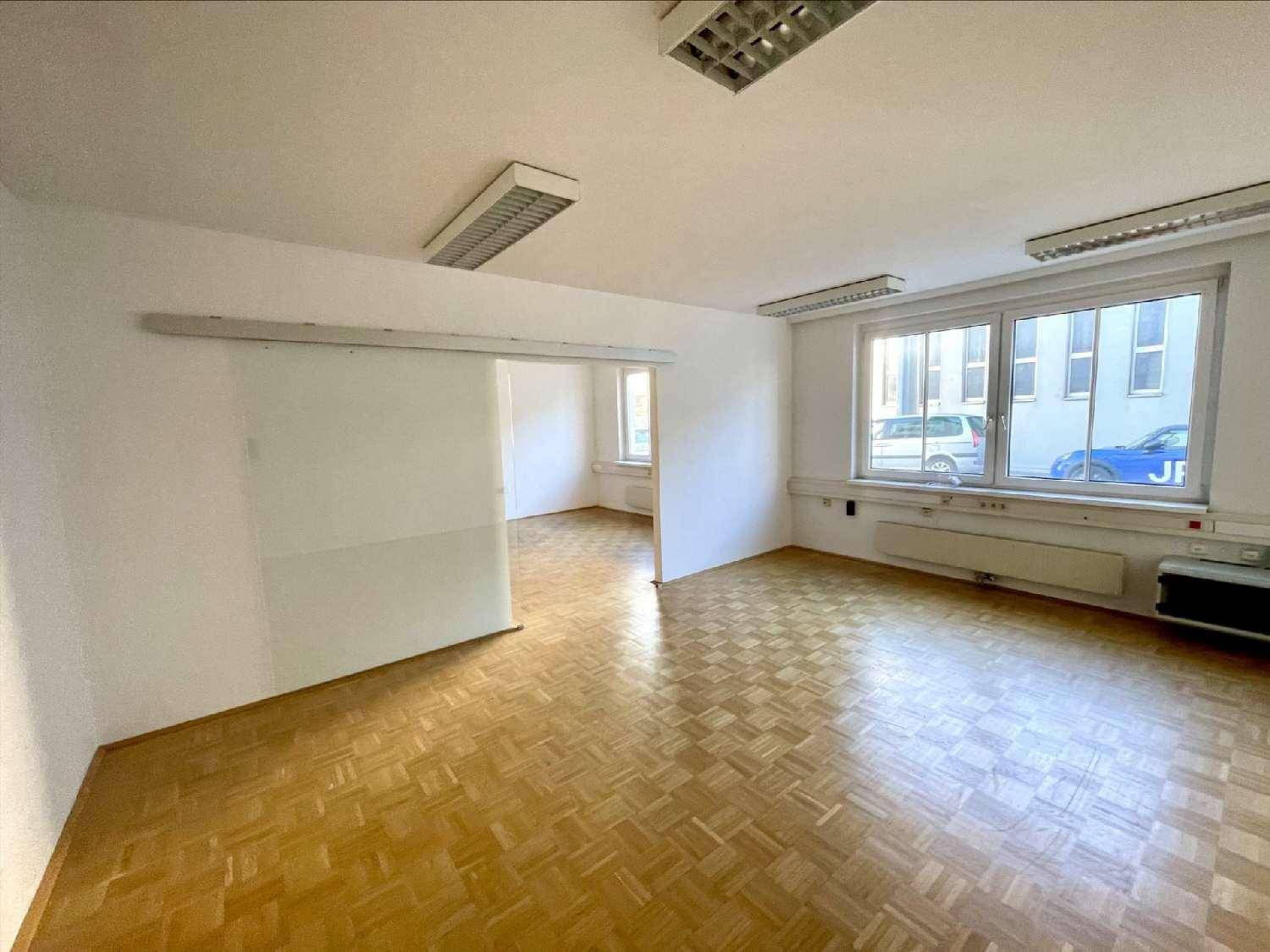 Büroraum mit Parkettboden und einer modernen Schiebetür, die den Raum unterteilt und Flexibilität bietet.