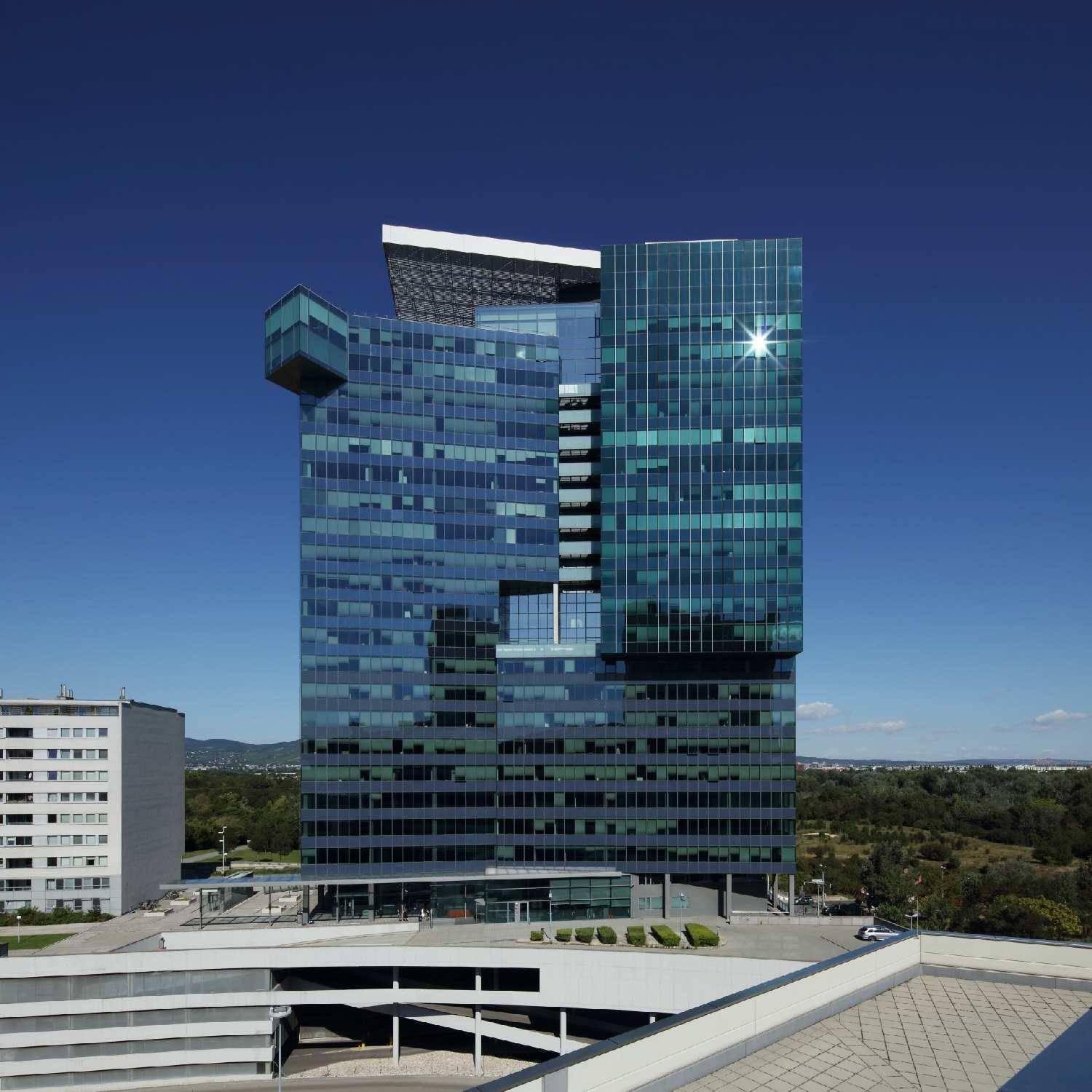 Beeindruckendes modernes Hochhaus mit Glasfassade und einzigartiger Architektur unter blauem Himmel.