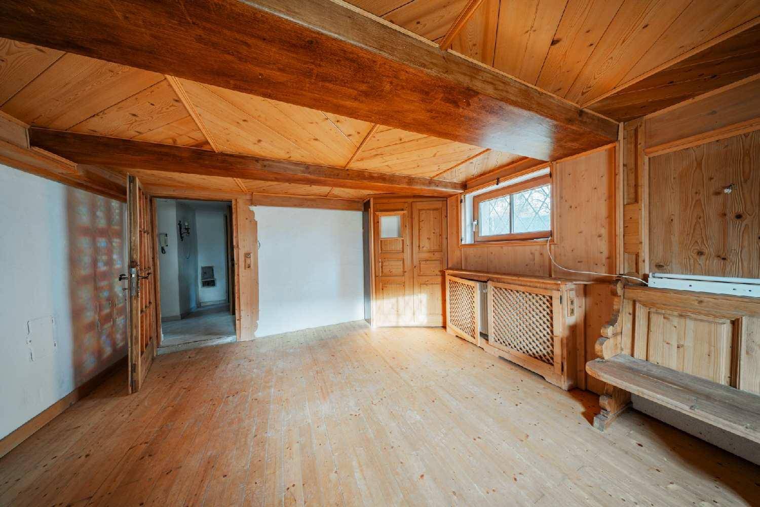 Rustikaler Raum mit umfassender Holzverkleidung an Wänden und Decke sowie Holzboden.