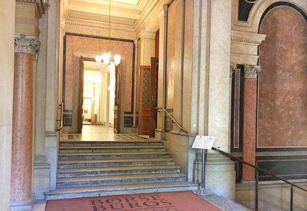 Prunkvoller Eingangsbereich mit Marmorverkleidung, hohen Decken und einer breiten Treppe.