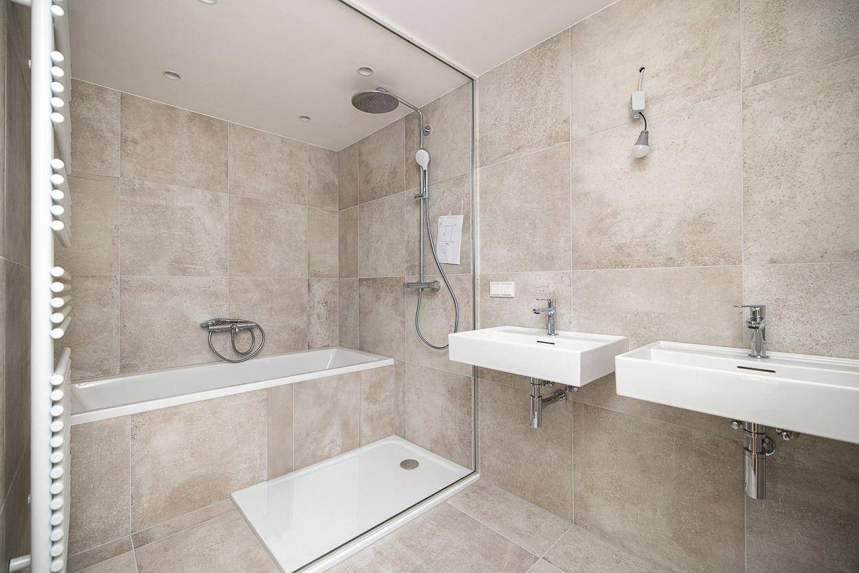 Modernes Badezimmer mit Doppelwaschbecken, Badewanne und begehbarer Dusche.