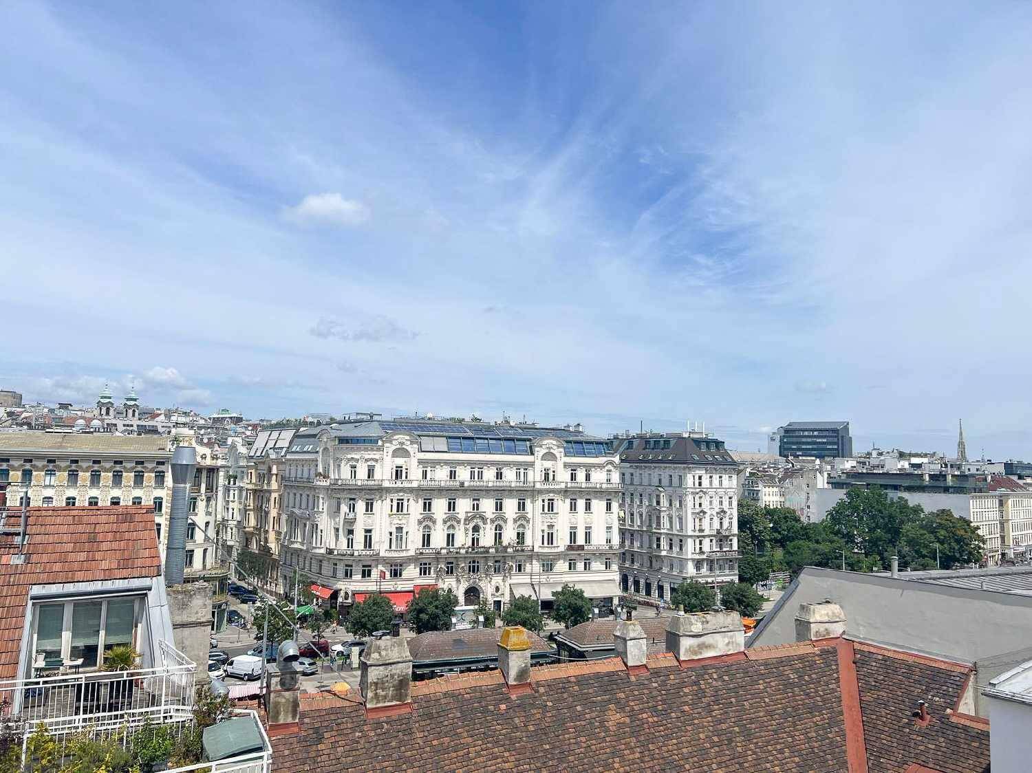 Panoramablick über die Dächer der Stadt mit historischen Gebäuden unter blauem Himmel.
