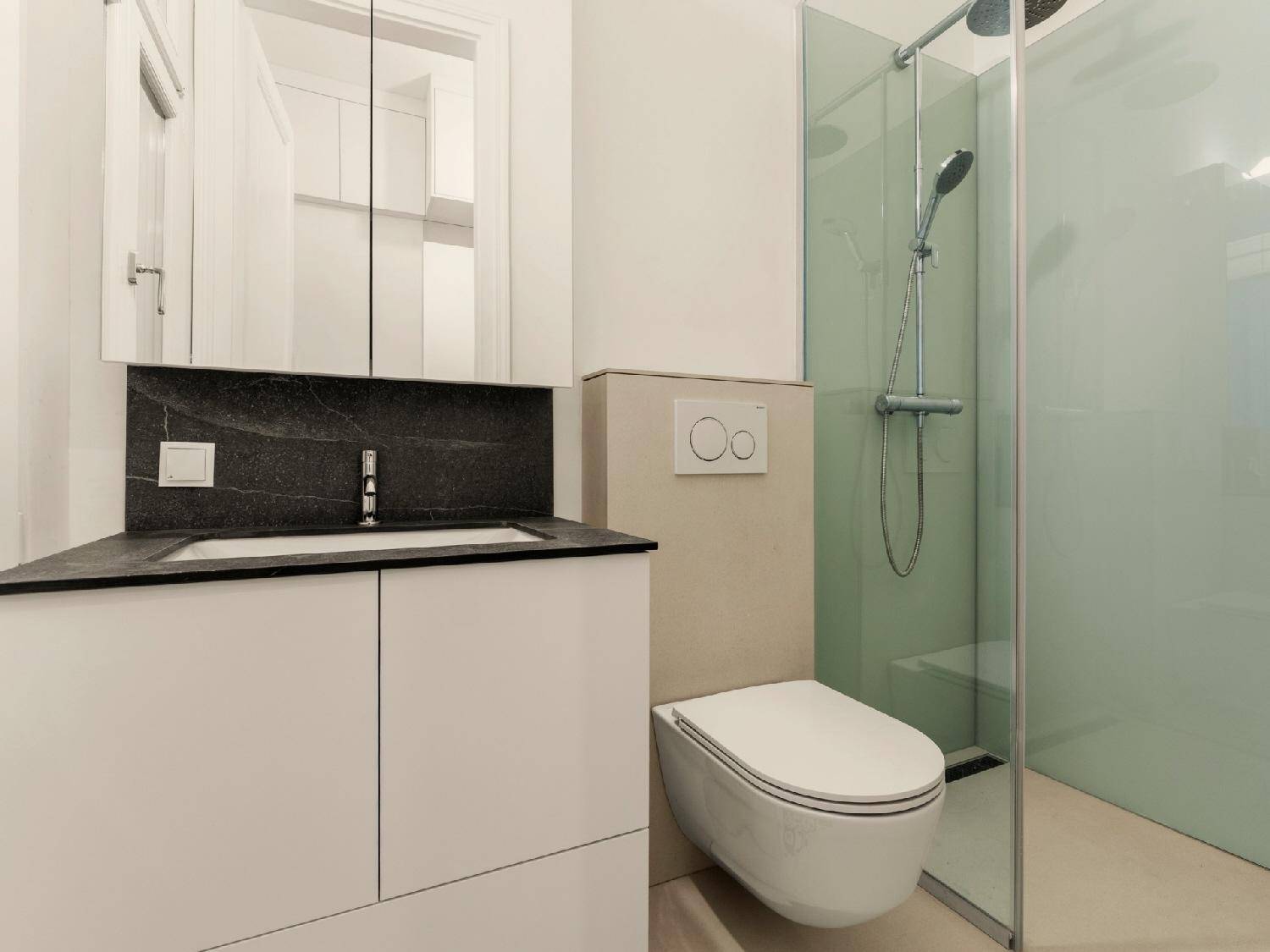 Modernes Badezimmer mit bodengleicher Dusche, wandhängendem WC und Einzelwaschbecken.