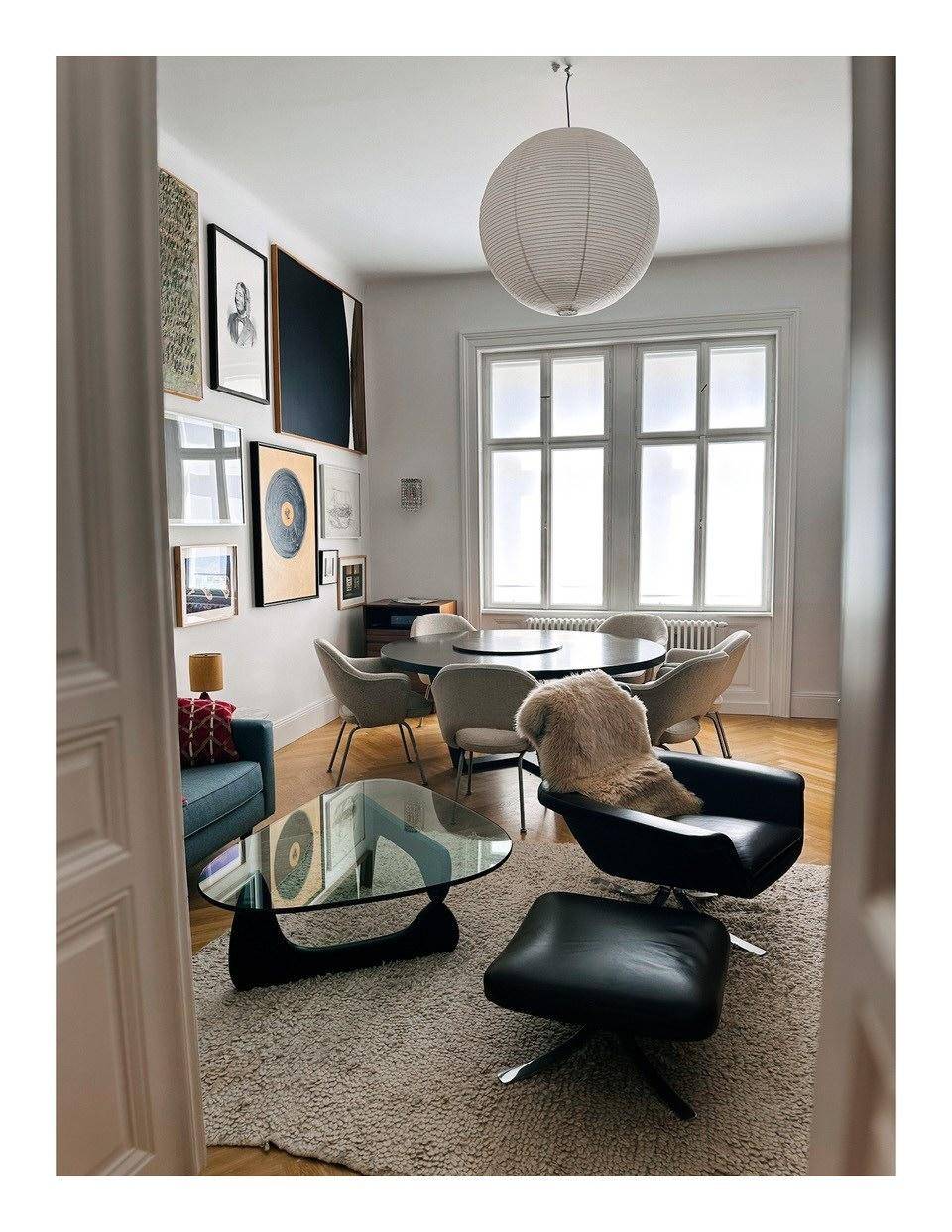 Stilvolles Wohn- und Esszimmer mit Kunstwerken, Designermöbeln und Parkettboden.