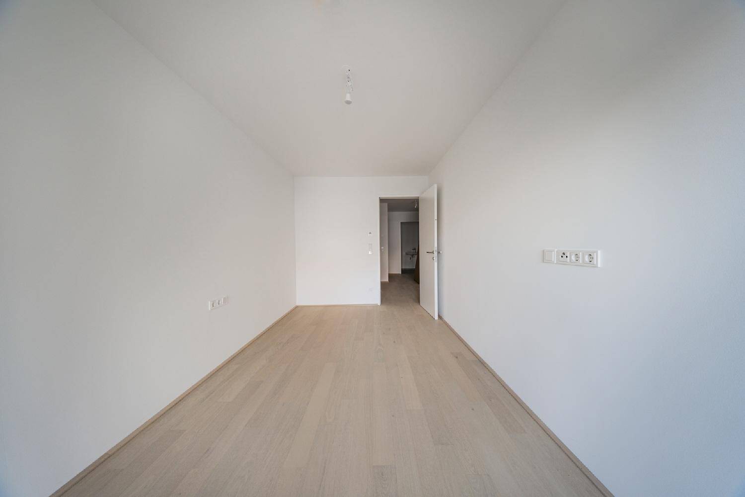 Leeres, helles Zimmer mit Parkettboden, bereit für individuelle Gestaltung und Nutzung.