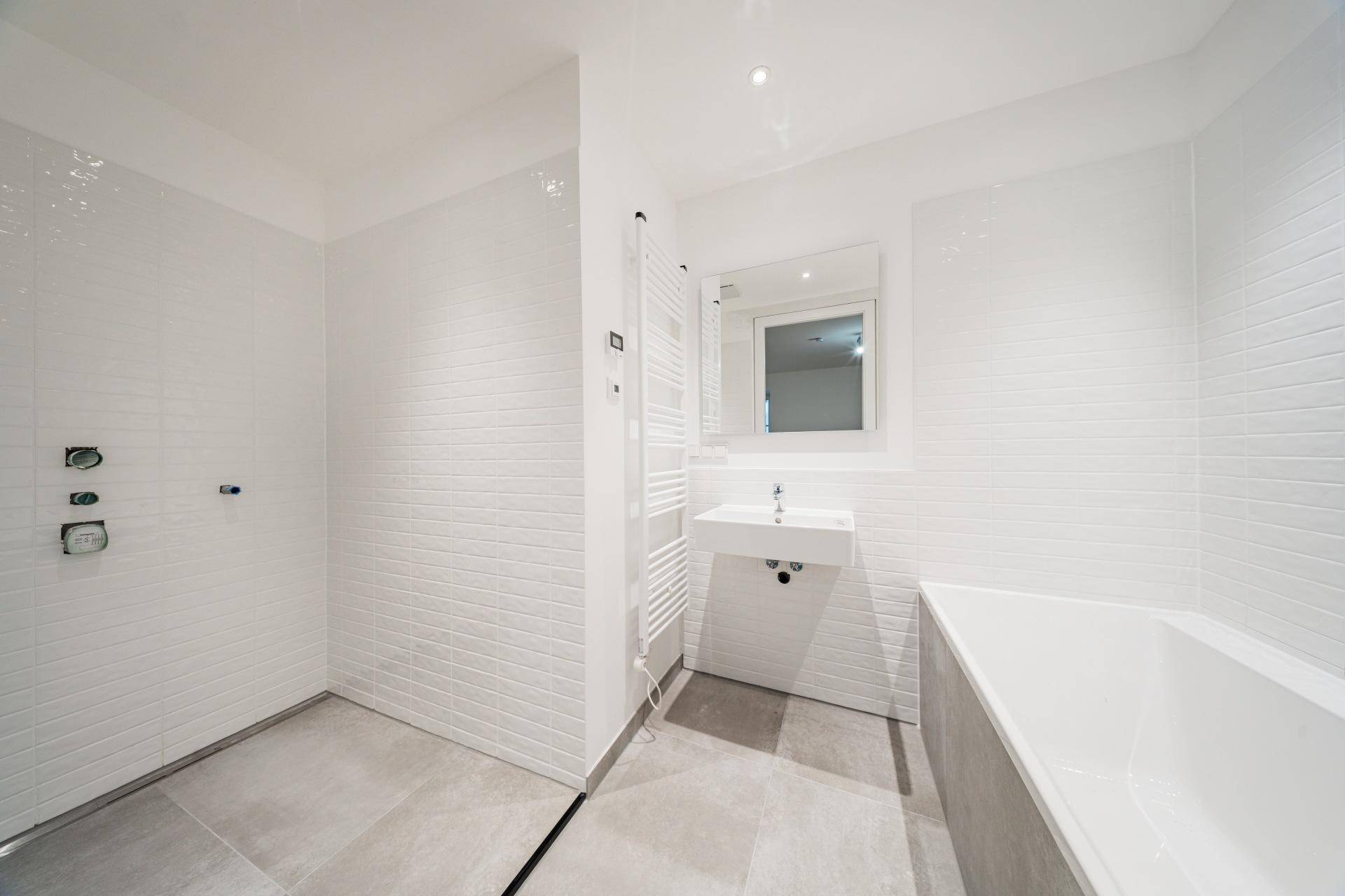 Modernes Badezimmer mit begehbarer Dusche, Badewanne, Einzelwaschbecken und Handtuchheizkörper.