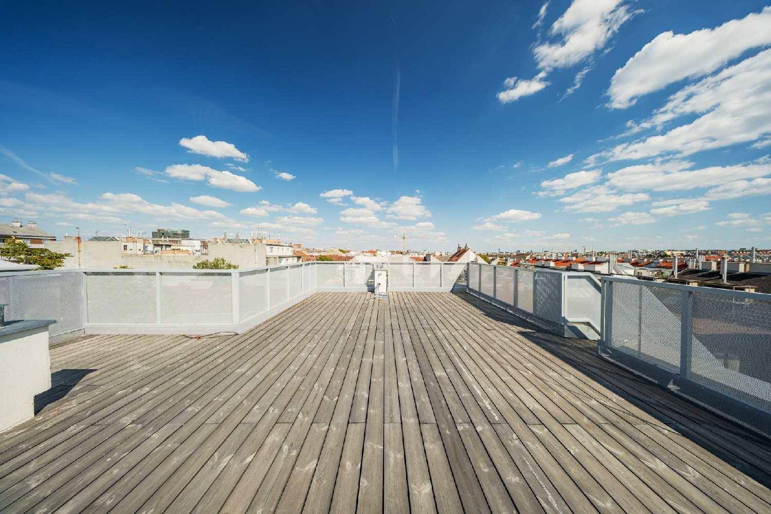 Weitläufige Dachterrasse mit Holzboden und Panoramablick über die Stadt.