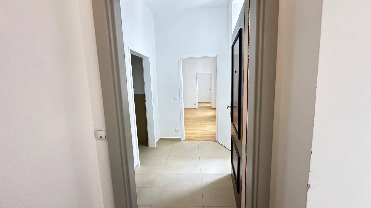 Langer Flur mit Fliesenboden, der zu den verschiedenen Zimmern der Wohnung führt und viel Platz bietet.