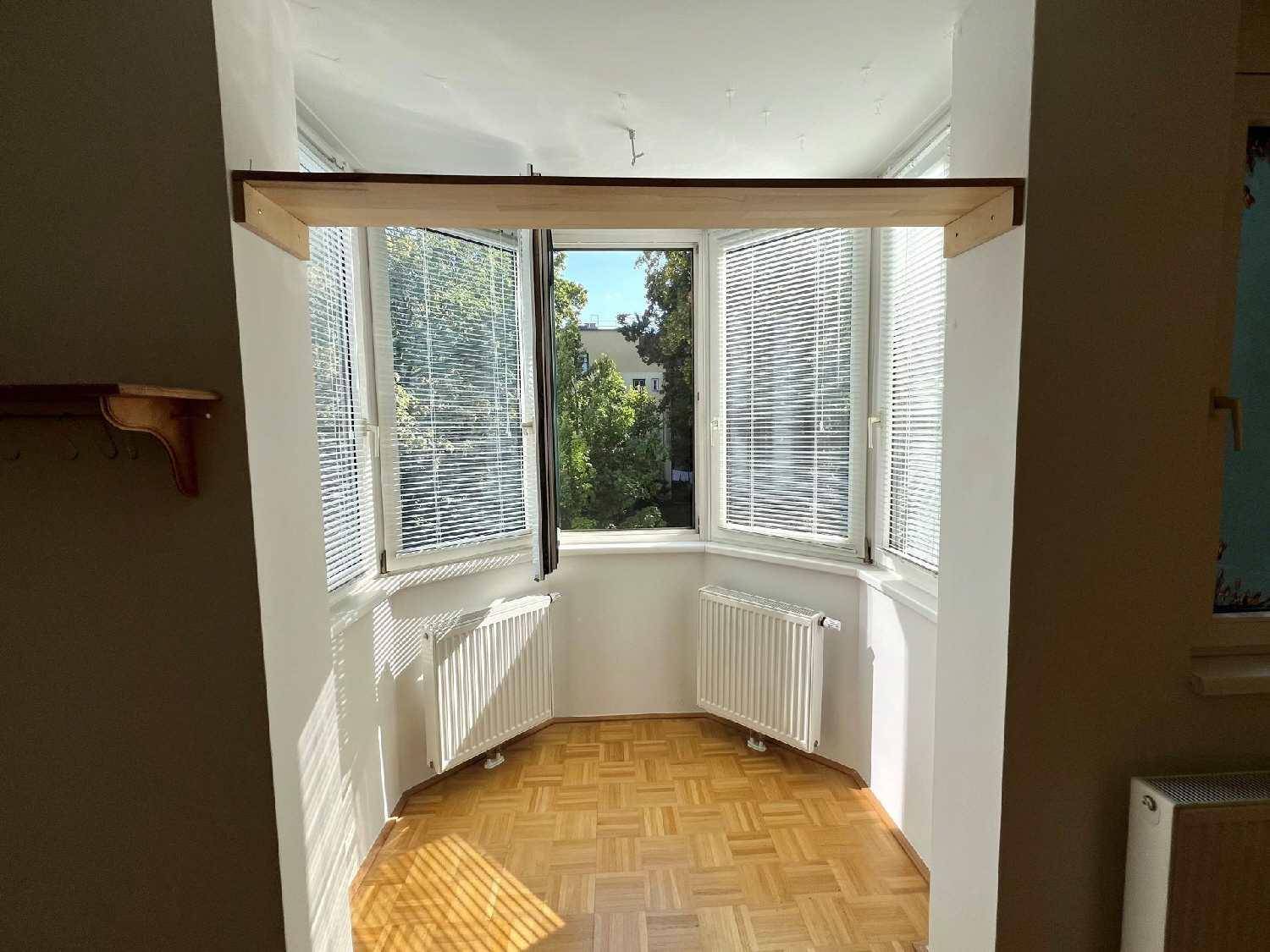 Heller Erkerbereich mit großen Fenstern und Blick ins Grüne, ideal als gemütliche Leseecke.