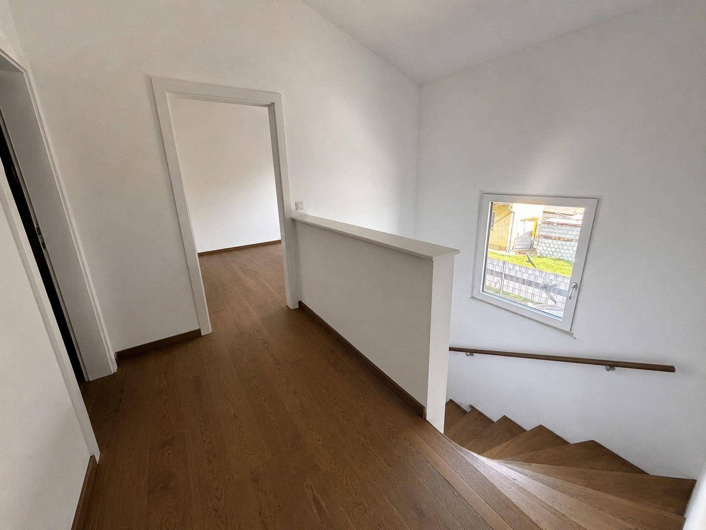 Heller Flurbereich mit Holzfußboden und Treppe, die in die obere Etage führt.