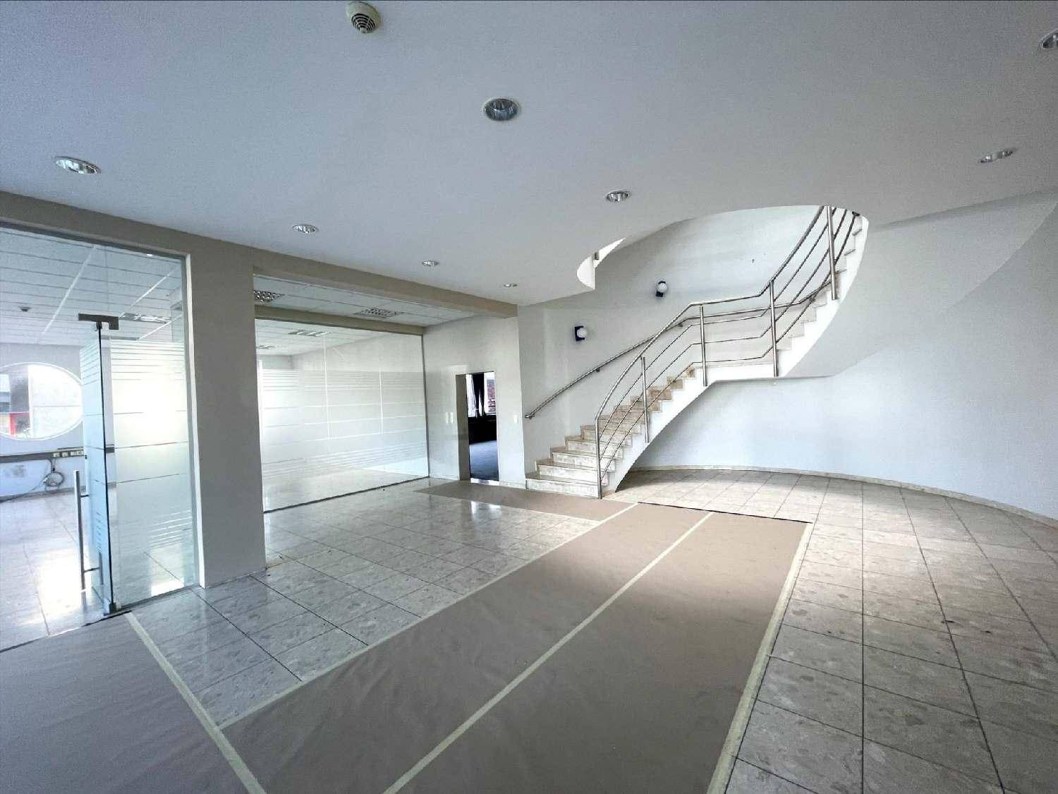 Empfangsbereich mit gefliestem Boden, geschwungener Treppe und vorbereiteten Bodenbelägen.