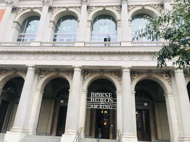 Eingangsbereich eines historischen Gebäudes mit der Aufschrift "BÖRSE BÜROS AM RING", umgeben von klassischen Säulen.