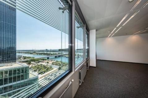 Helles Büro mit raumhohen Fenstern, Teppichboden und Panoramablick auf die Stadt und den Fluss.