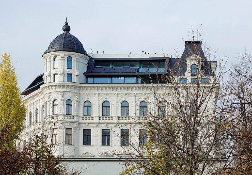Historisches Gebäude mit moderner Dachaufstockung und eleganter Architektur.