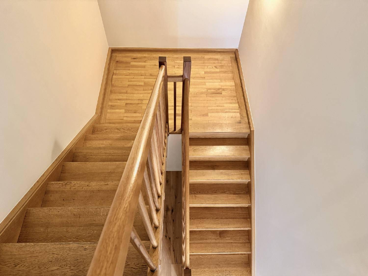 Massive Holztreppe mit passendem Geländer, die in die oberen Etagen führt.