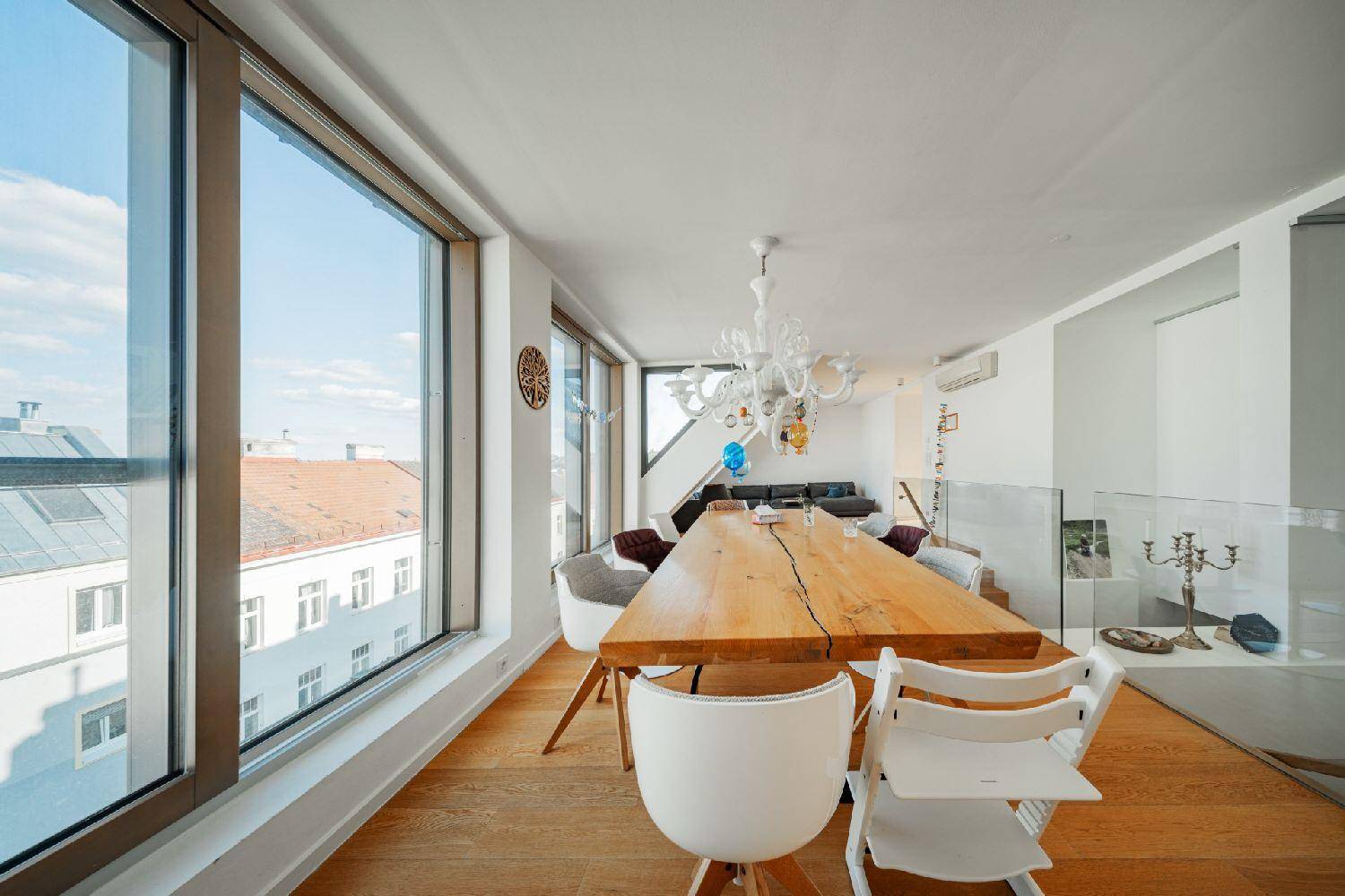 Geräumiger Essbereich mit großem Holztisch, modernen Stühlen und weitem Blick.