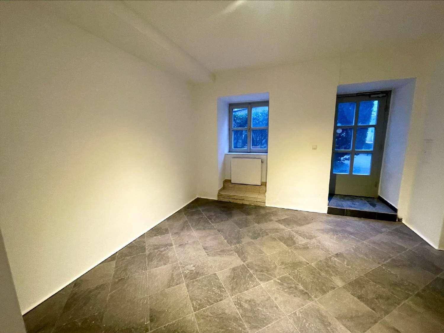 Leerer Raum mit Fliesenboden, einem Fenster und einer Tür, ideal für ein kleines Büro oder Geschäft.
