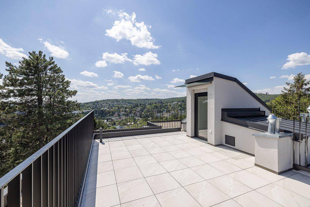 Weitläufige Dachterrasse mit Panoramablick über die grüne Umgebung und den Himmel.