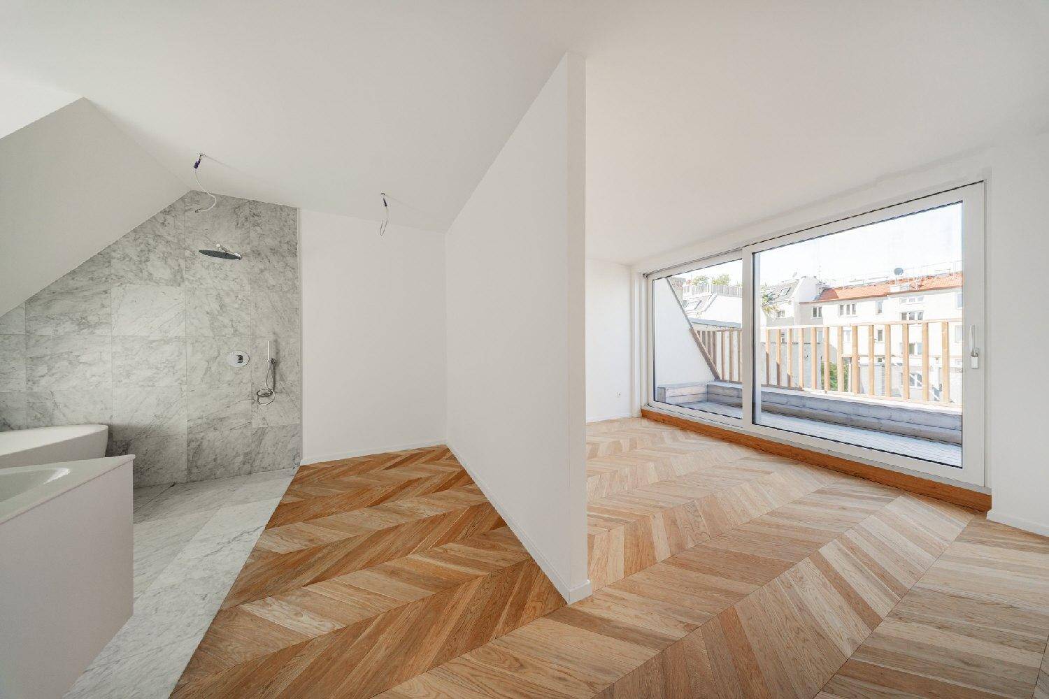 Kombination aus einem hellen Zimmer mit Parkett und einem luxuriösen Badezimmer mit Marmorfliesen.
