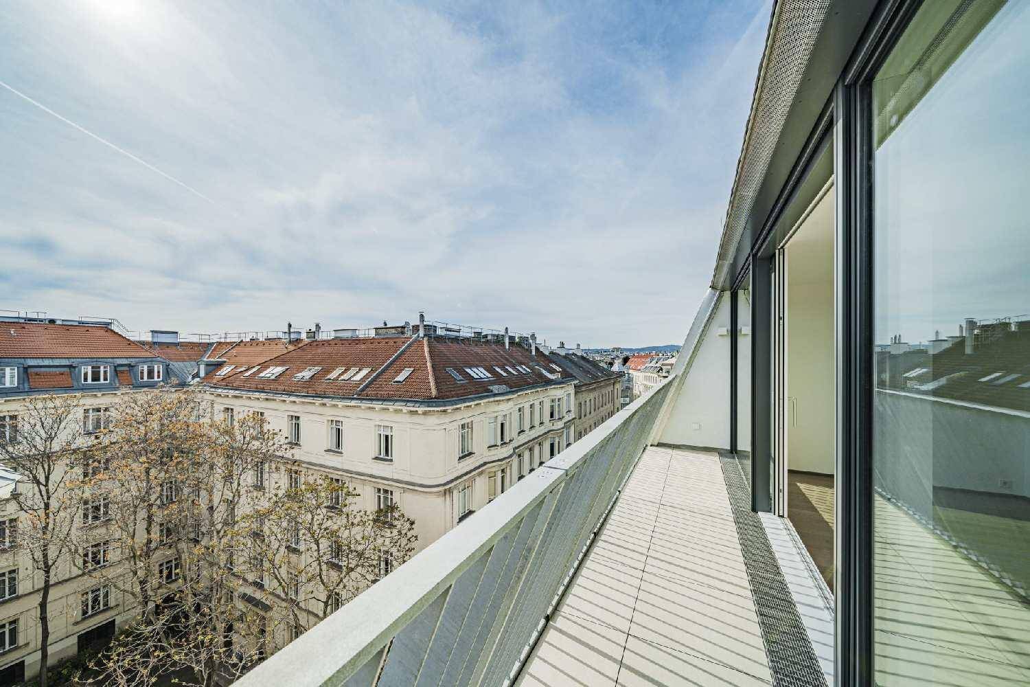Langer Balkon mit Metallgeländer und weitem Blick über die Dächer der Stadt.