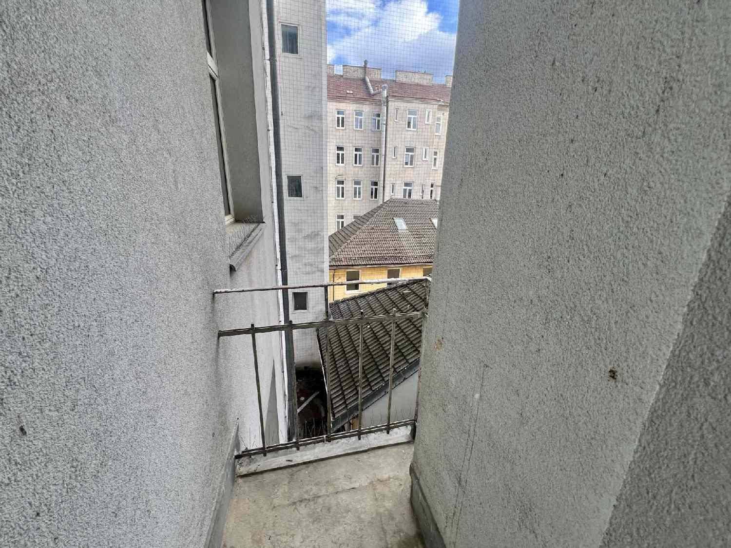 Schmaler Balkon mit Metallgeländer und Blick auf die umliegenden Gebäude.