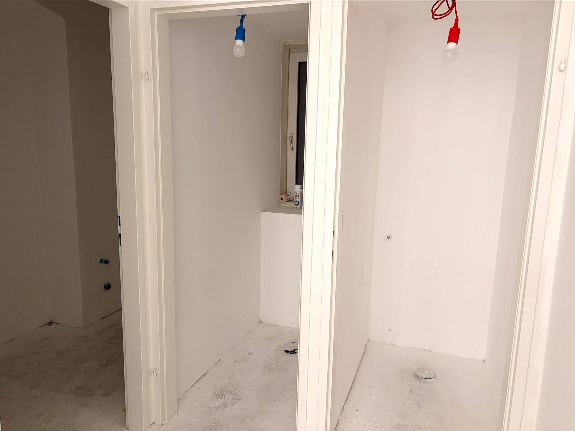 Zwei kleine, leere Räume mit weißen Wänden, einer davon mit Fenster, im Rohbauzustand.