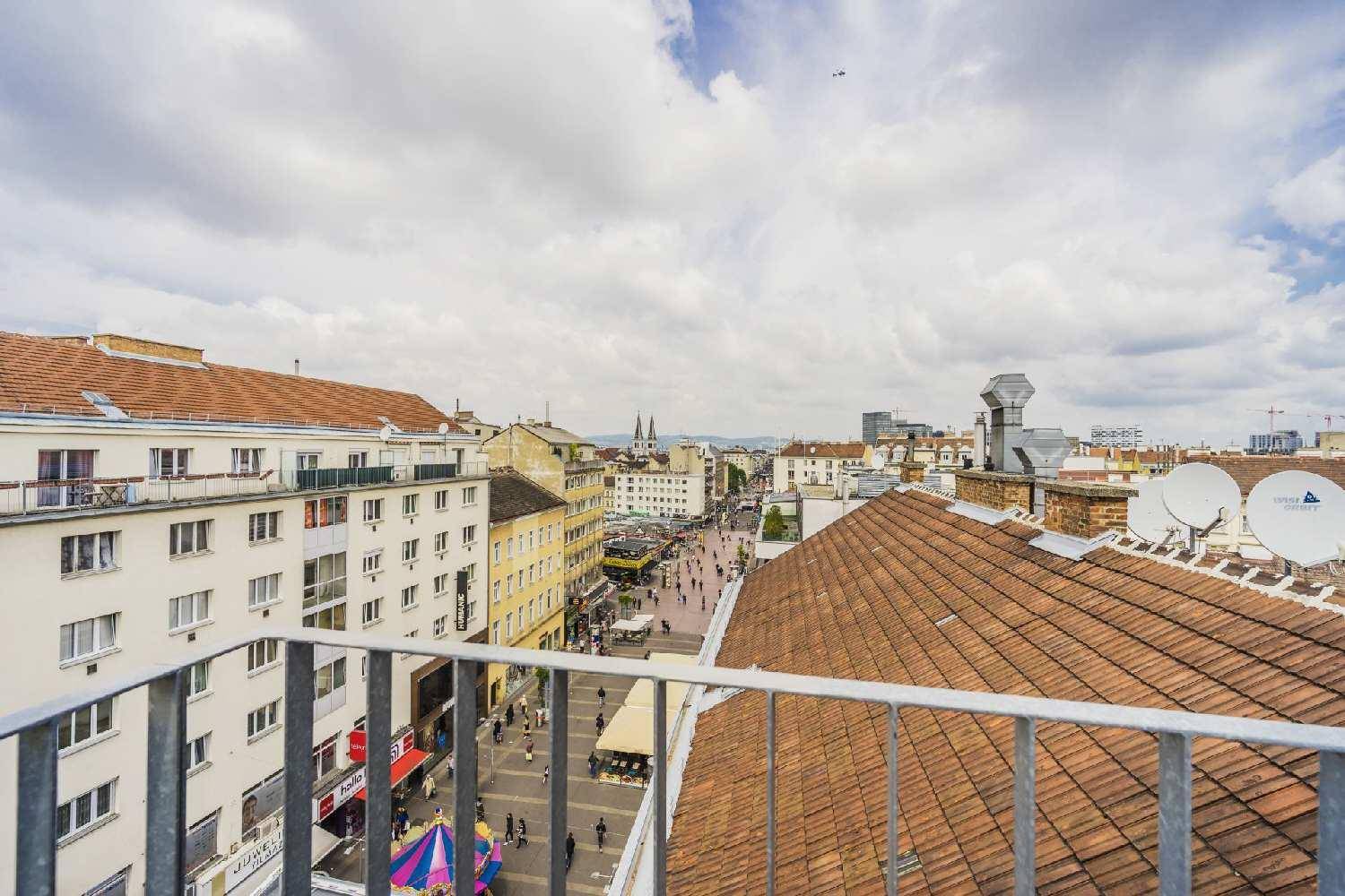 Panoramablick über die Stadt von einem erhöhten Punkt, mit Dächern und belebten Straßen.