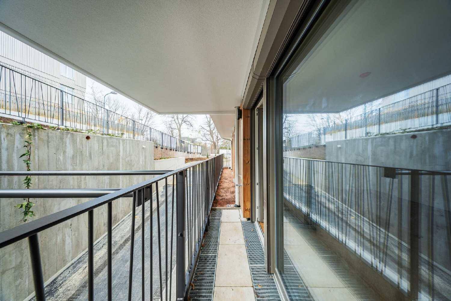 Langer, schmaler Balkon mit Metallgeländer und Blick auf die Umgebung.