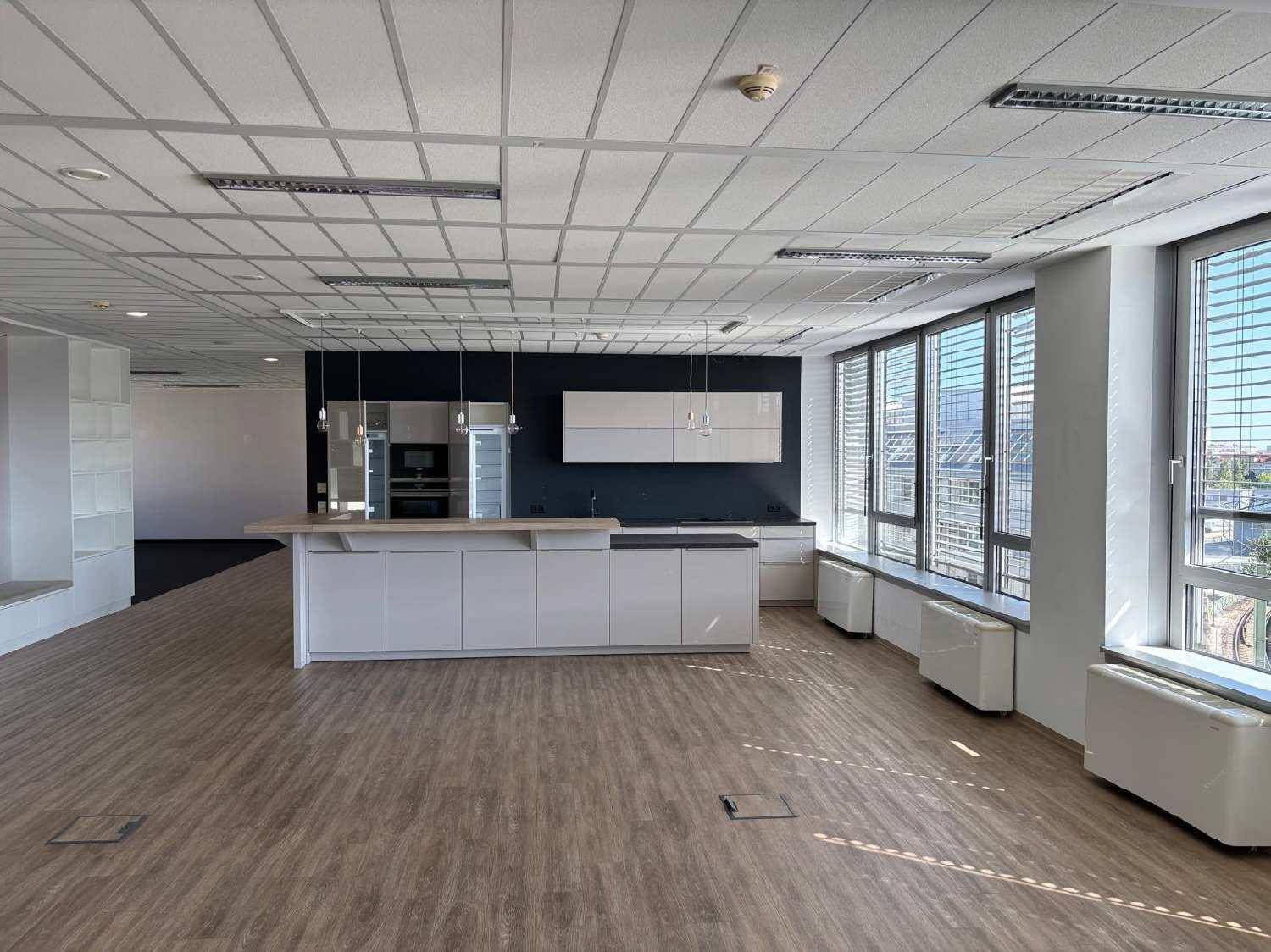 Geräumiges Büro mit moderner Küchenzeile, viel Tageslicht und weitem Blick nach draußen, perfekt für Pausen.